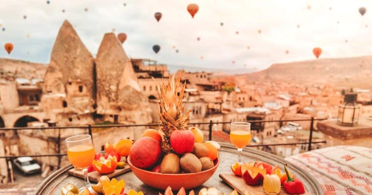 Göreme - Kappadokien - bunte Heißluftballons fliegen über die Stadt bei Reise und Urlaubsziele