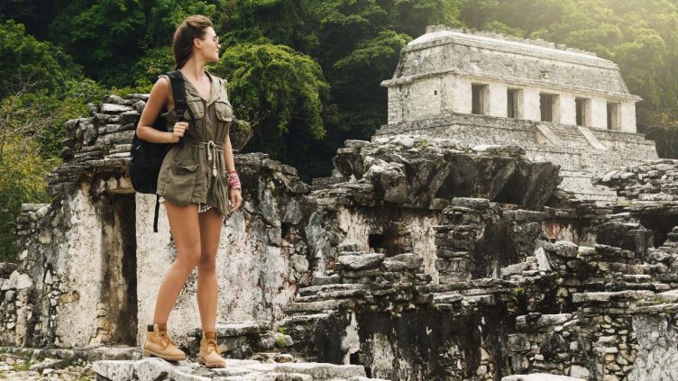 Palenque - Frau steht vor Maya Tempel bei Reise und Urlaubsziele